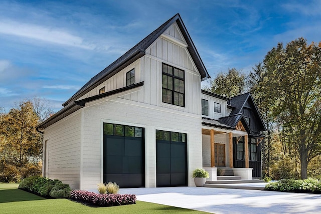 view of front of property with metal roof, an attached garage, concrete driveway, board and batten siding, and a standing seam roof