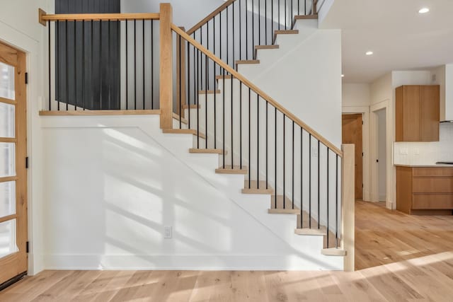 stairs with recessed lighting, baseboards, and wood finished floors