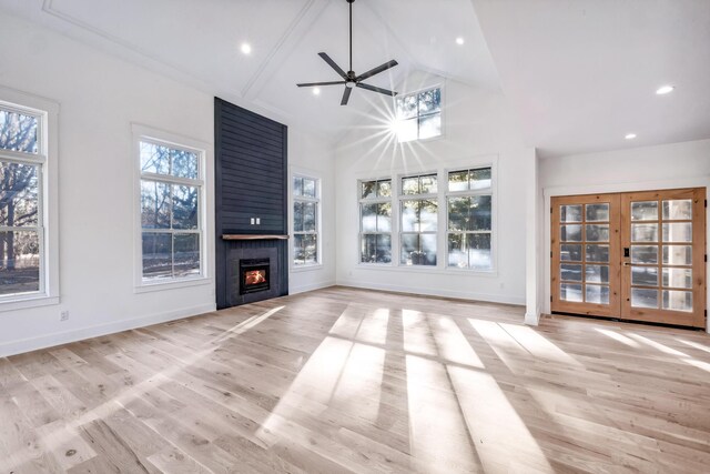 unfurnished living room with wood finished floors, a wealth of natural light, and baseboards