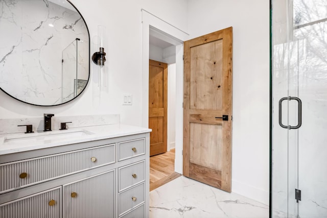 bathroom with marble finish floor, vanity, and a marble finish shower