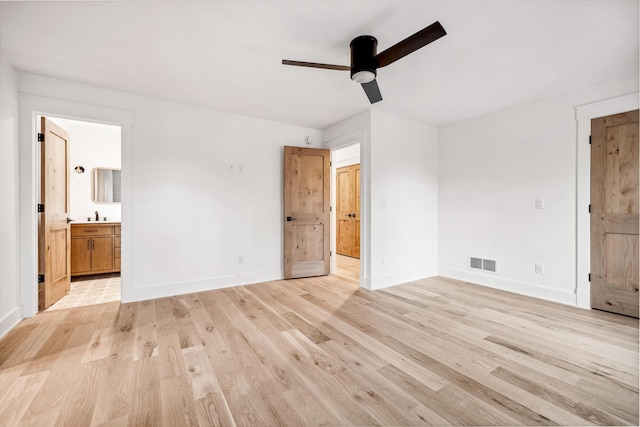 unfurnished bedroom featuring connected bathroom, visible vents, and light wood-style floors