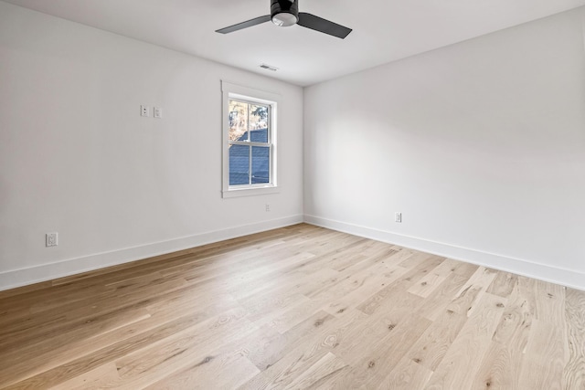 unfurnished room with ceiling fan, light wood-type flooring, visible vents, and baseboards