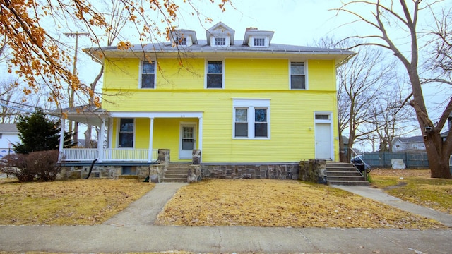 traditional style home featuring covered porch and fence