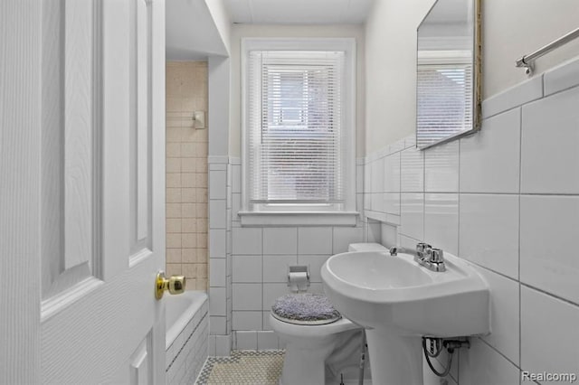 full bath featuring tile walls, toilet, and a healthy amount of sunlight