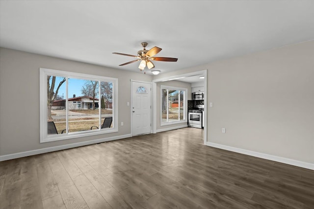 unfurnished living room featuring dark wood-style floors, a ceiling fan, and baseboards