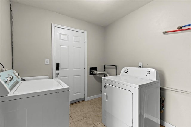 washroom featuring light tile patterned floors, laundry area, independent washer and dryer, and baseboards