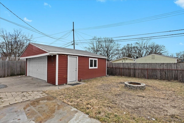 view of outbuilding with a fire pit, fence, and an outbuilding