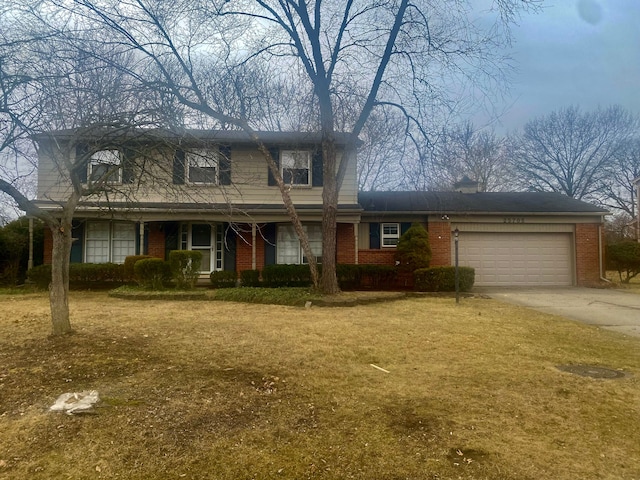 traditional home with driveway, brick siding, an attached garage, and a front yard