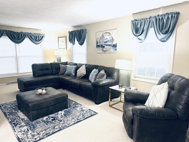 living area featuring a wealth of natural light, light carpet, and visible vents