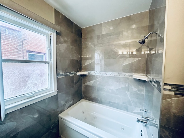 full bathroom featuring a combined bath / shower with jetted tub, tile walls, and a healthy amount of sunlight