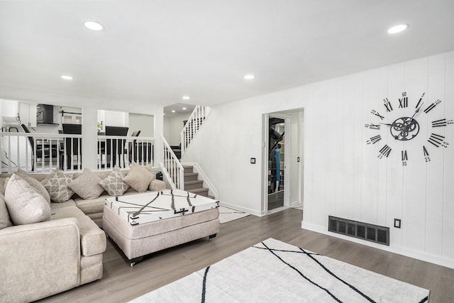 living area with stairway, visible vents, wood finished floors, and recessed lighting