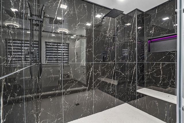 bathroom featuring a marble finish shower