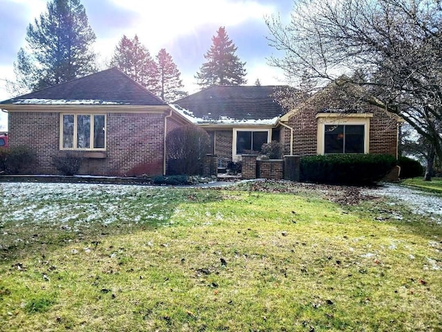 exterior space with brick siding and a lawn