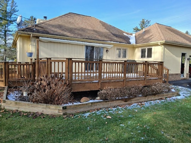 back of property featuring a deck and a shingled roof