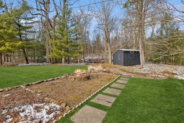 view of yard featuring a fire pit, a storage shed, and an outdoor structure