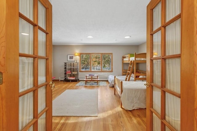 interior space with recessed lighting, wood finished floors, and french doors