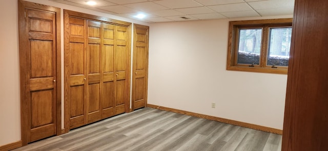 3075 Mineral Springs Trl, Mount Pleasant, MI 48858 - unfurnished bedroom with light wood-style floors, baseboards, a paneled ceiling, and a closet