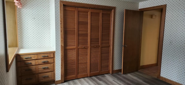 3075 Mineral Springs Trl, Mount Pleasant, MI 48858 - unfurnished bedroom with a closet, light wood-type flooring, baseboards, and wallpapered walls