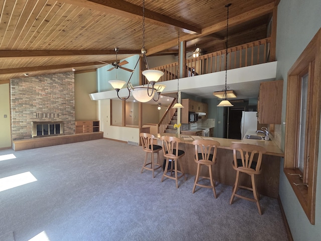 3075 Mineral Springs Trl, Mount Pleasant, MI 48858 - carpeted dining space with wood ceiling, beamed ceiling, a sink, high vaulted ceiling, and a brick fireplace