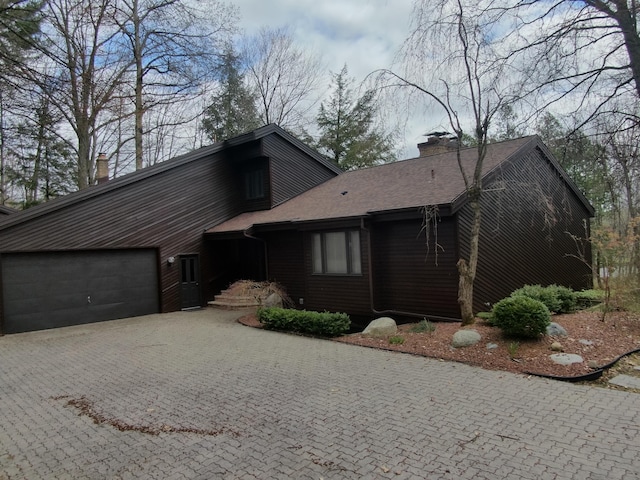 3075 Mineral Springs Trl, Mount Pleasant, MI 48858 - mid-century home featuring a chimney, an attached garage, and driveway