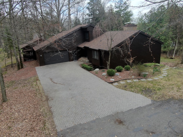 3075 Mineral Springs Trl, Mount Pleasant, MI 48858 - view of front of house featuring a chimney, decorative driveway, a shingled roof, and a garage