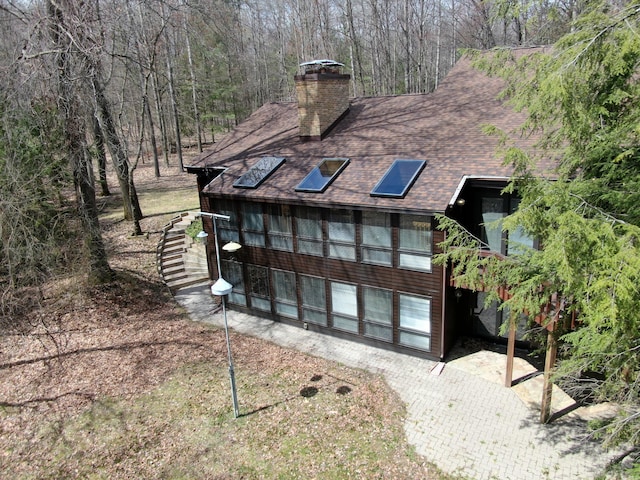 3075 Mineral Springs Trl, Mount Pleasant, MI 48858 - back of house with a chimney, stairway, and a shingled roof