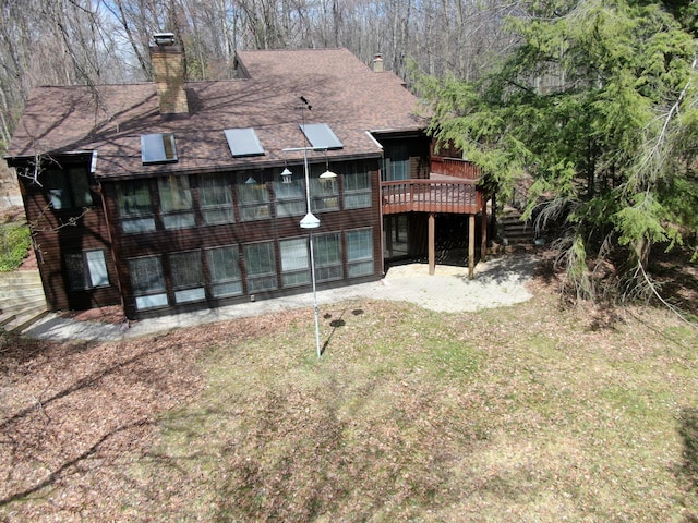 3075 Mineral Springs Trl, Mount Pleasant, MI 48858 - rear view of property featuring a chimney, a wooden deck, and a shingled roof