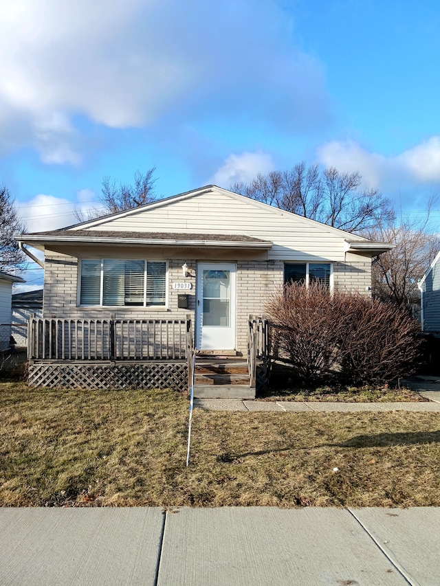 view of front of home featuring brick siding and a front lawn