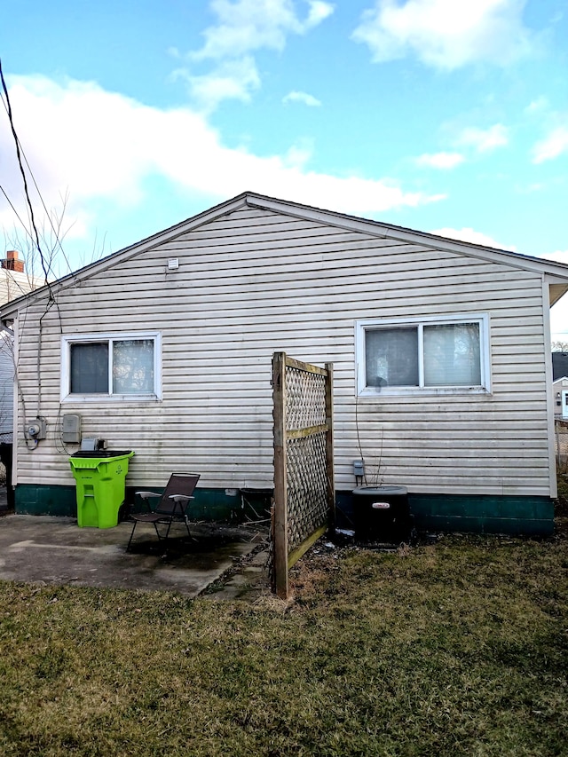 back of property featuring a patio area, central air condition unit, and a lawn