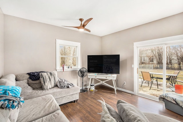 living area with a healthy amount of sunlight, a ceiling fan, baseboards, and wood finished floors