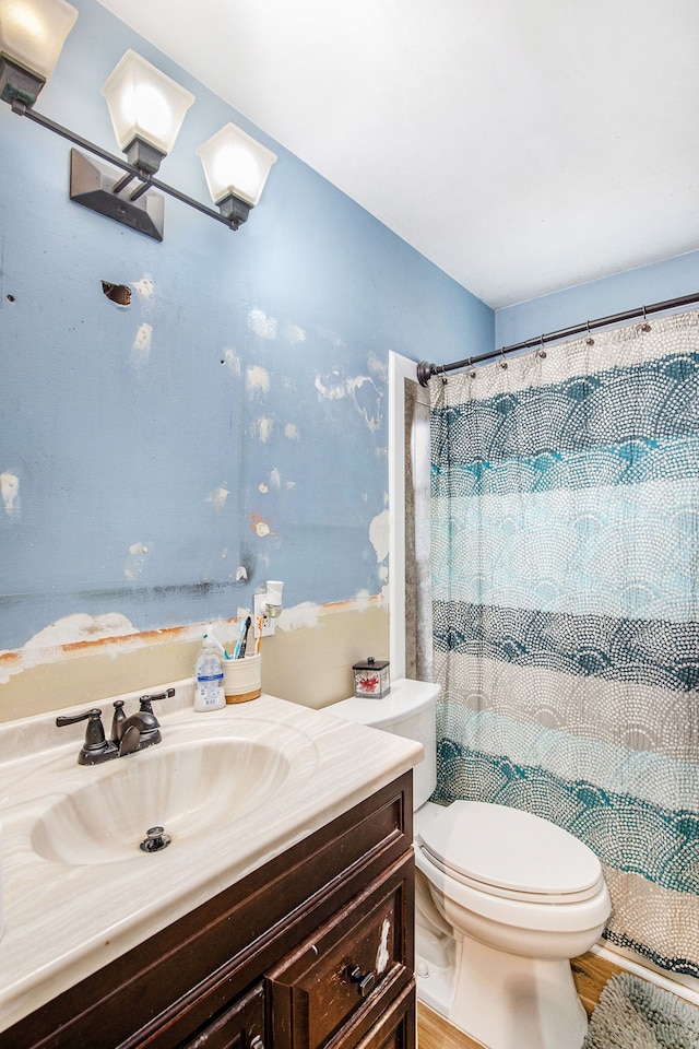 bathroom featuring vanity, wood finished floors, toilet, and a shower with curtain