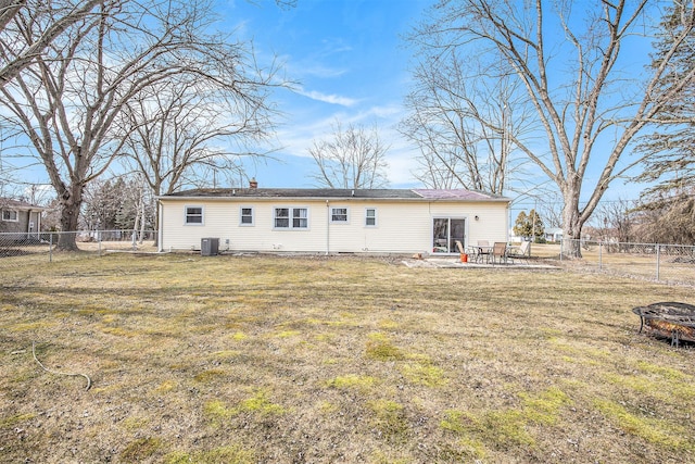 back of property with central AC unit, a lawn, a chimney, a fenced backyard, and a patio