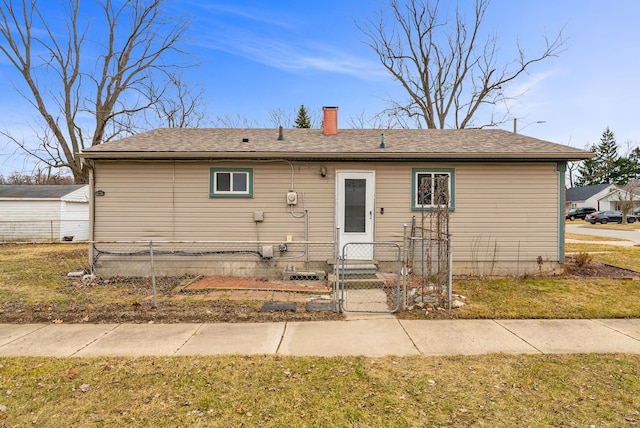 view of front of property featuring a chimney, fence, and roof with shingles