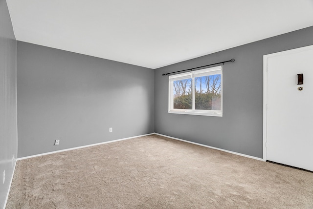 unfurnished room featuring carpet floors and baseboards