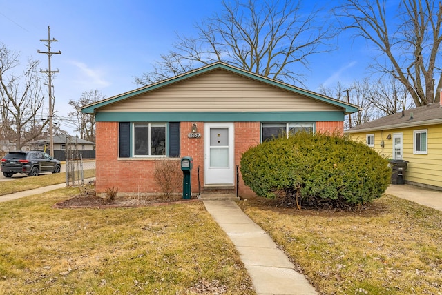 bungalow-style house with a front yard and brick siding