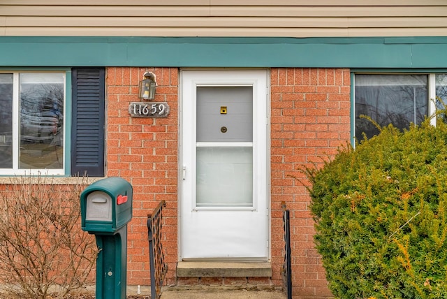 doorway to property featuring brick siding