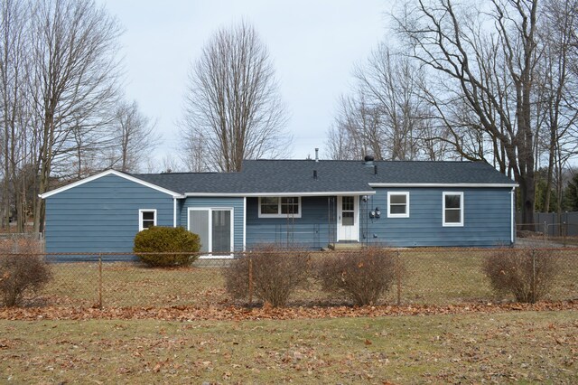 ranch-style house featuring fence private yard, roof with shingles, and a front lawn