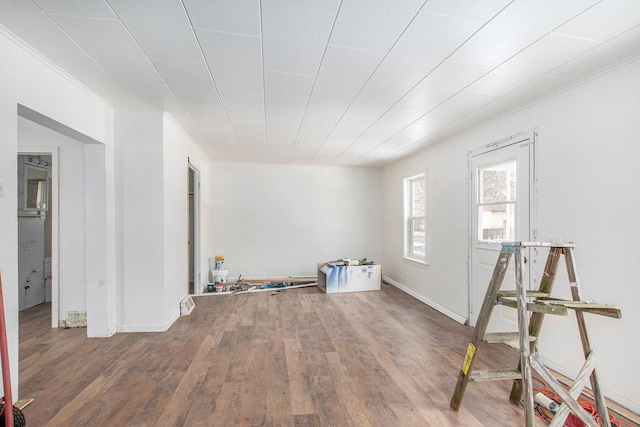 spare room with ornamental molding, wood finished floors, and baseboards