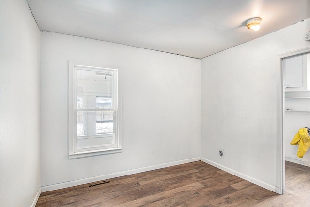 empty room with baseboards, visible vents, and wood finished floors