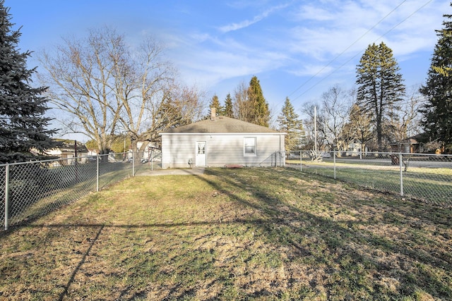 rear view of house featuring a fenced backyard and a lawn