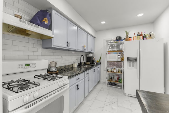 kitchen featuring backsplash, under cabinet range hood, marble finish floor, white appliances, and a sink