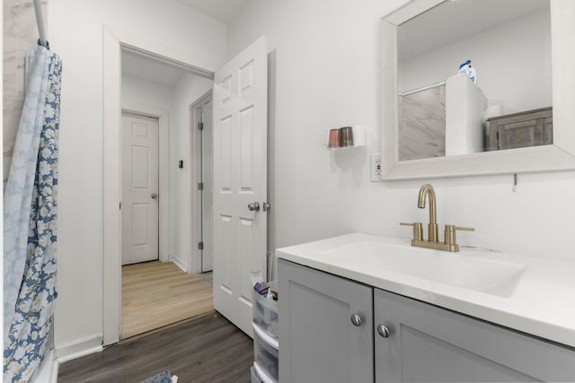 bathroom with vanity, a shower with shower curtain, wood finished floors, and baseboards