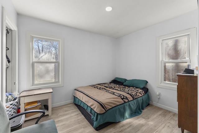 bedroom with baseboards and light wood finished floors