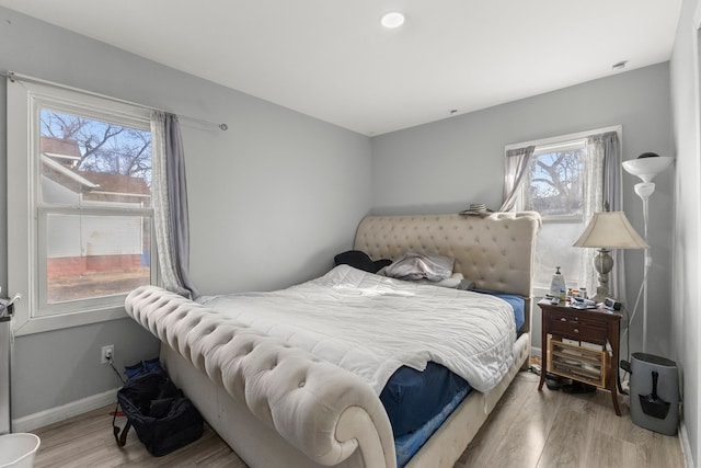 bedroom with baseboards and light wood finished floors