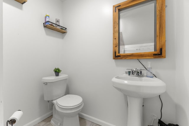 bathroom with toilet and baseboards