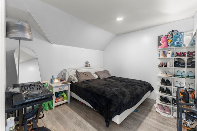 bedroom featuring lofted ceiling and wood finished floors