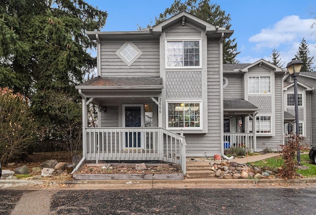 traditional home featuring a shingled roof and covered porch