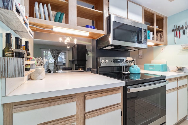 kitchen with stainless steel appliances, light countertops, and white cabinetry