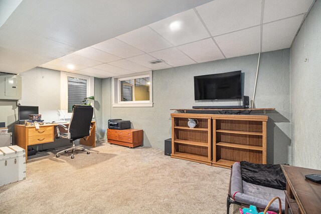 carpeted home office featuring electric panel, a drop ceiling, a textured wall, and visible vents