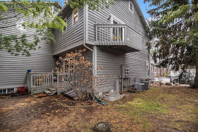 view of side of home with a balcony and central air condition unit